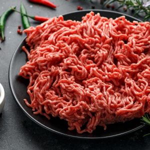 Fresh Raw mince, Minced beef, ground meat with herbs and spices on black plate